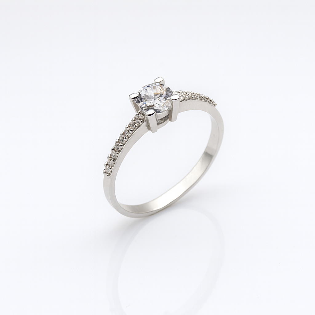 Inel de logodnă rafinat din argint 925, având o piatră centrală din zirconiu alb montată pe un design modern și delicat. Bijuteria cântărește aproximativ 1.65 grame, este livrată într-o cutie de bijuterii elegantă, însoțită de factură și certificat de conformitate. Simbolizează iubirea eternă, promisiunea și eleganța autentică.