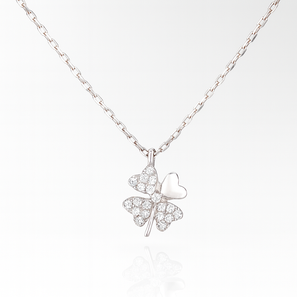 Colier trifoi cu patru foi din argint 925 rodiat cu pandantiv strălucitor și inimă, simbol al norocului și iubirii, pe fundal alb lucios 
