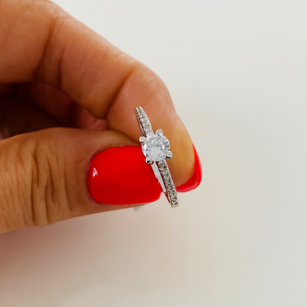 Inel de logodnă rafinat din argint 925, având o piatră centrală din zirconiu alb montată pe un design modern și delicat. Bijuteria cântărește aproximativ 1.65 grame, este livrată într-o cutie de bijuterii elegantă, însoțită de factură și certificat de conformitate. Simbolizează iubirea eternă, promisiunea și eleganța autentică, in mana
