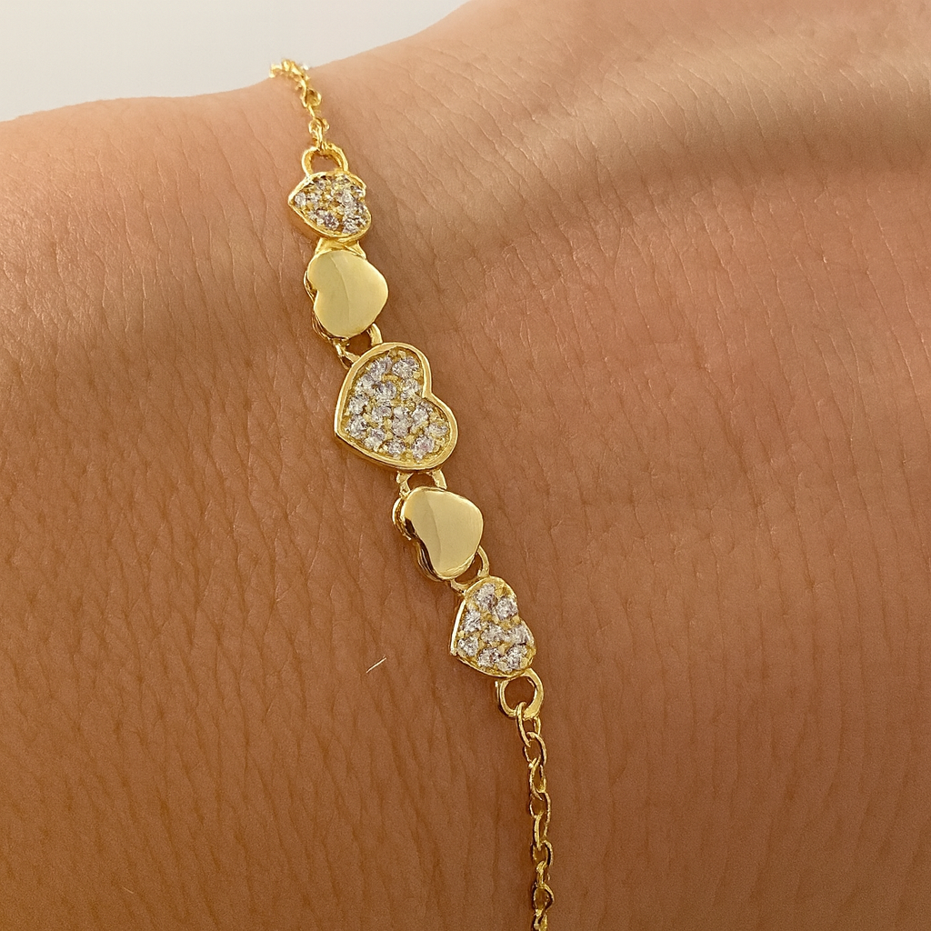 Brățară elegantă din argint 925 placat cu aur de 14K, model cu inimioare strălucitoare, simbol al iubirii și conexiunii, fotografie pe fundal alb lucios, prezentare pe mana