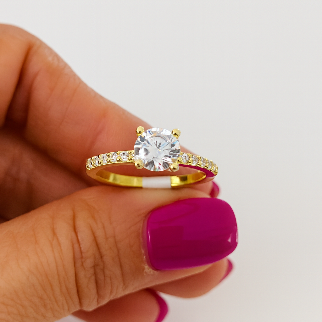 inel de logodnă din argint 925 placat cu aur de 14K, cu piatră centrală strălucitoare și cristale laterale, fotografiat pe fundal alb lucios, bijuterie elegantă pentru femei, in mana